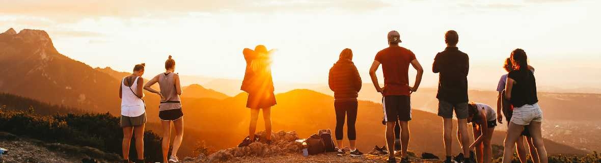 group of people on a mountain at sunset